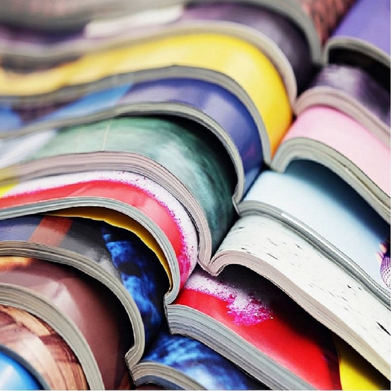 Image de plusieurs magasines colorés, ouverts et empilés les uns au dessus des autres